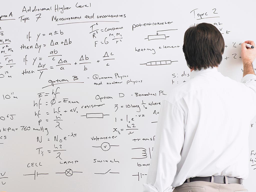 Math professor writing formula on white board
