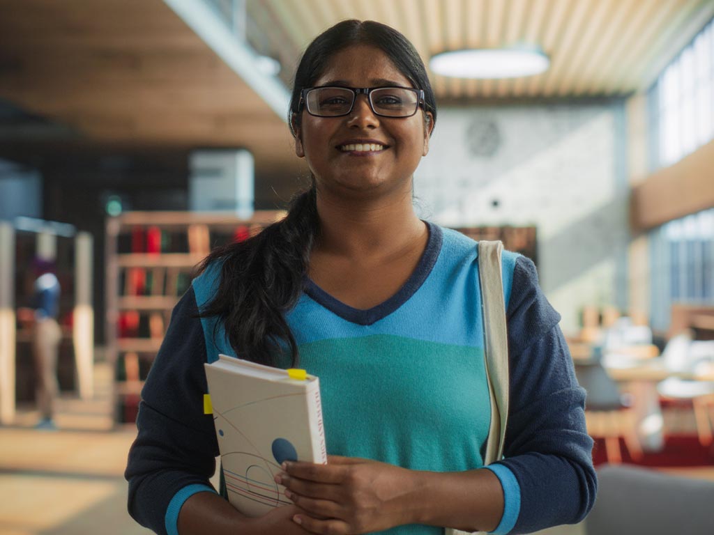 Smiling university student in library